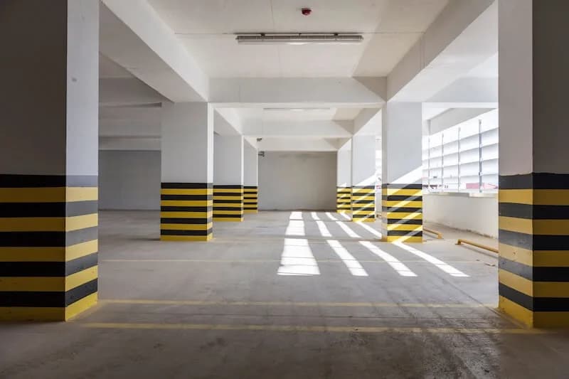Parqueadero cubierto de un conjunto, con las columnas demarcadas en amarillo y negro