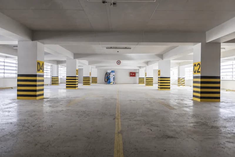 Parqueadero cubierto de un conjunto residencial, con las columnas demarcadas y los puestos numerados